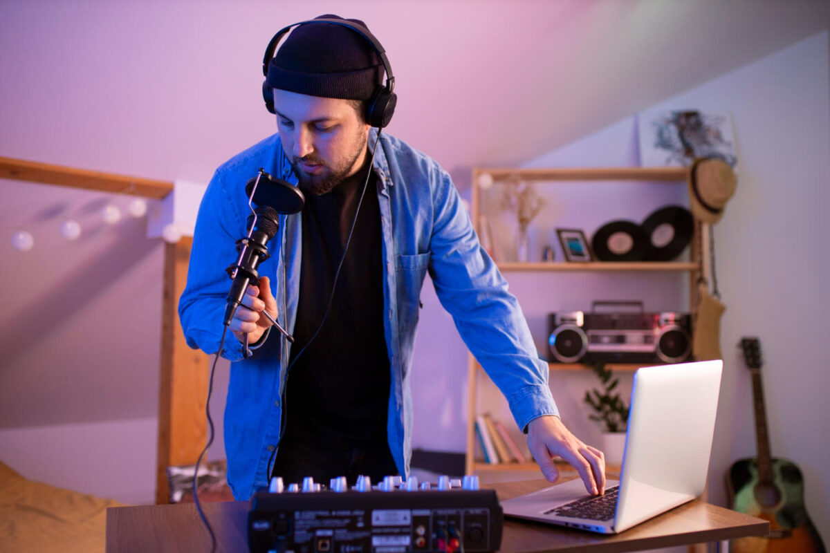 Independent musician using Spotify for Artists on a laptop in a home studio